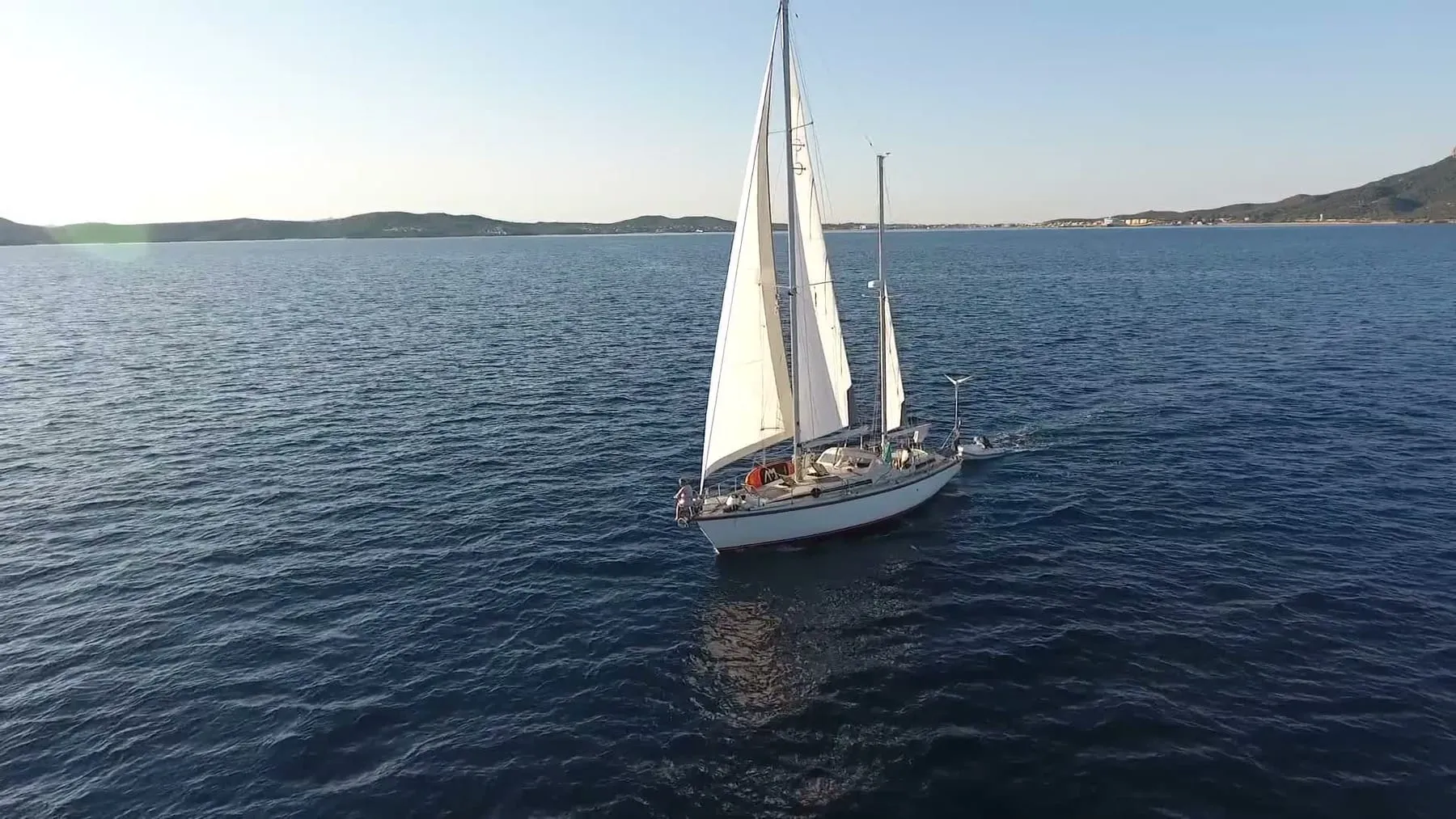 A ketch under sail on open water, seen from above