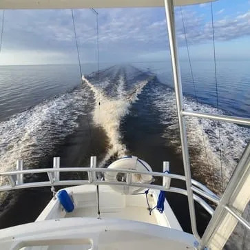 A wide wake trailing astern on calm offshore water