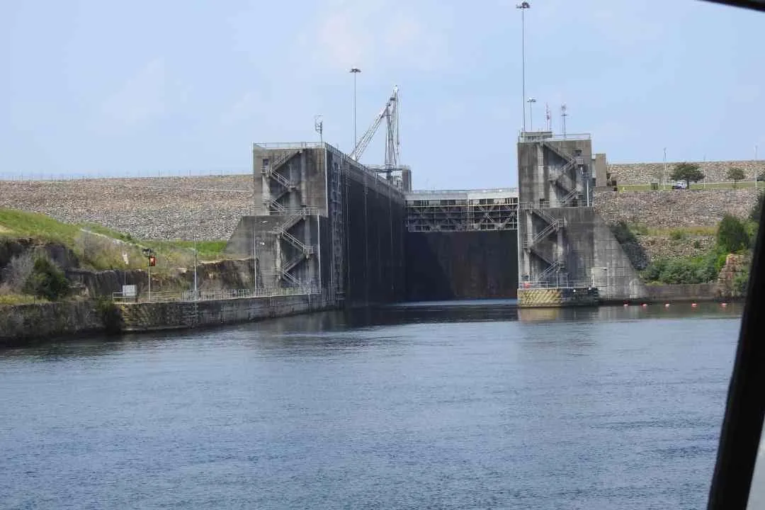 A river lock with its steel gates closed and concrete chamber walls