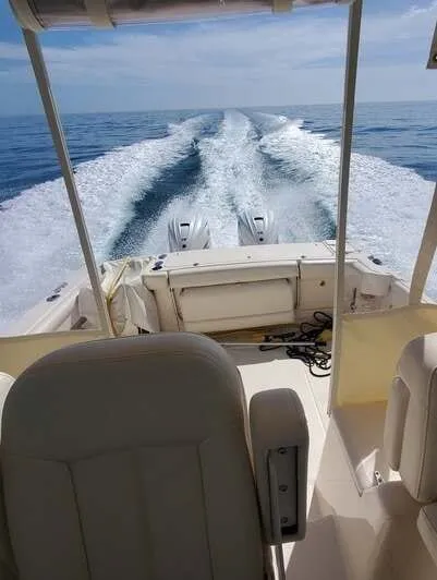 Looking aft from the helm seat past twin outboards to the wake astern